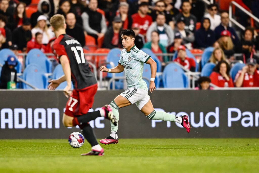 Luiz Araujo dribbling the ball forward in attack